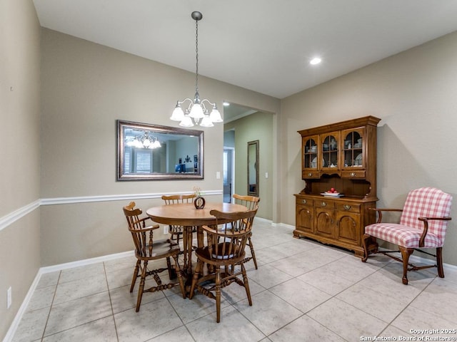 dining space with a chandelier, baseboards, and light tile patterned flooring