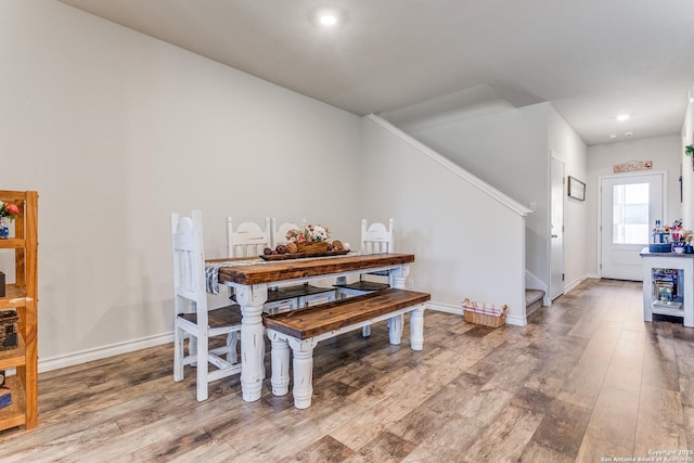 dining space featuring stairway, wood finished floors, and baseboards