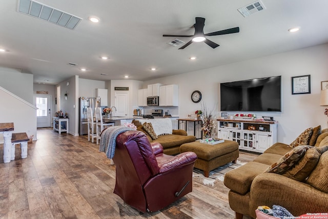 living area with visible vents, dark wood finished floors, and a ceiling fan