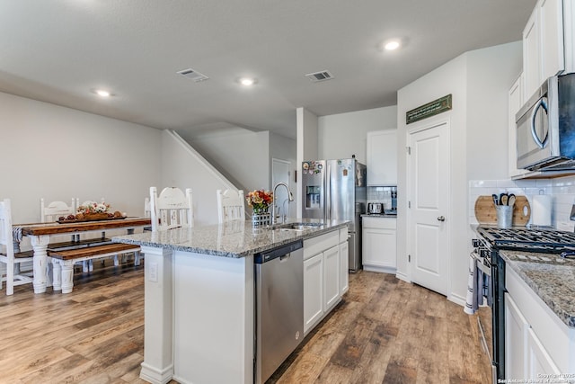 kitchen featuring a sink, visible vents, light wood finished floors, and stainless steel appliances