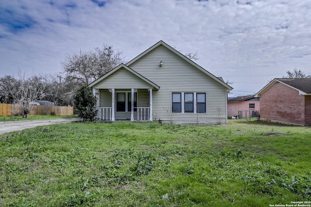 bungalow-style house with a porch, a front lawn, and fence