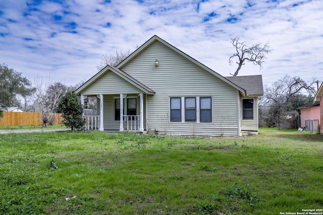 bungalow-style home with a porch, a front lawn, and fence