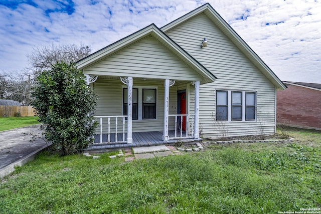 bungalow-style house with covered porch and fence