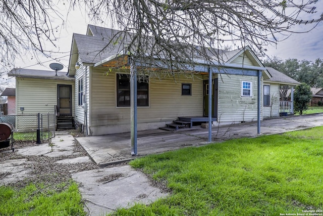 rear view of house featuring a lawn, a patio, and fence