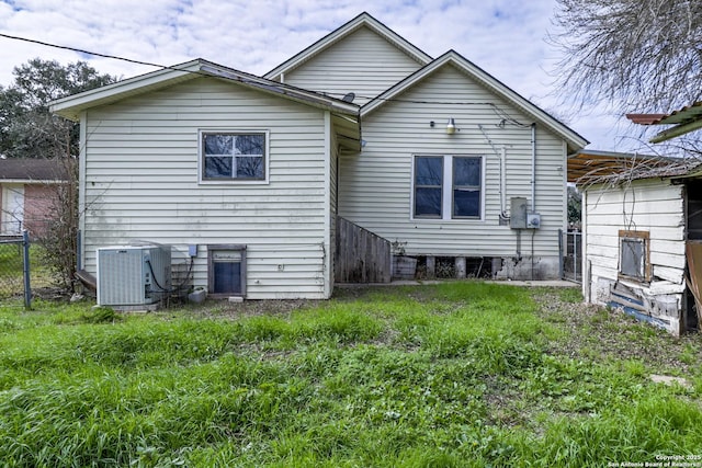 back of property featuring central air condition unit and fence