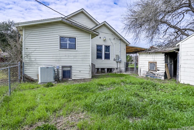 back of house with an attached carport, central AC unit, and fence