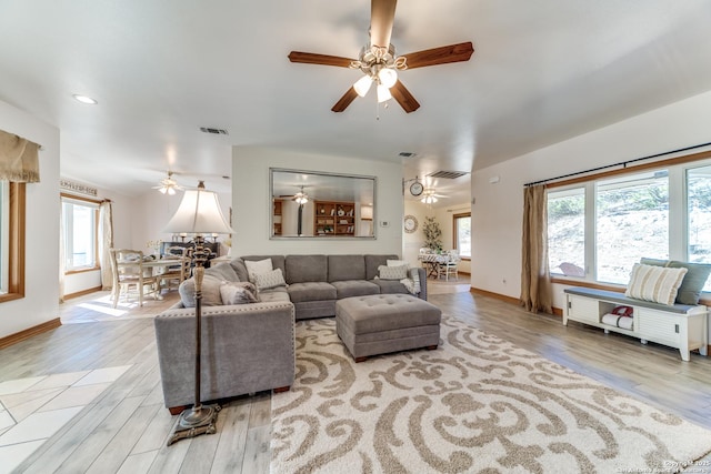 living room with visible vents, plenty of natural light, ceiling fan, and light wood-style flooring