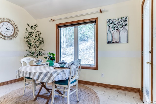 dining space featuring vaulted ceiling, a healthy amount of sunlight, and baseboards