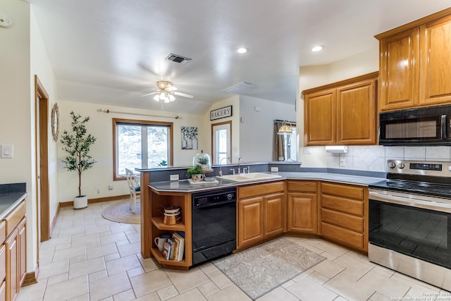 kitchen featuring visible vents, a peninsula, a sink, black appliances, and backsplash