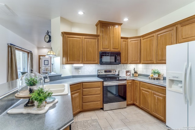 kitchen featuring electric range, a sink, white refrigerator with ice dispenser, black microwave, and tasteful backsplash