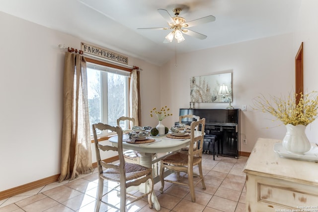 dining area featuring light tile patterned floors, a ceiling fan, and baseboards