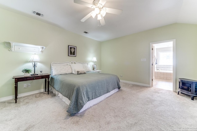 bedroom with a wood stove, carpet flooring, baseboards, and visible vents