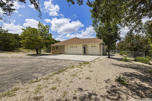 view of home's exterior featuring concrete driveway, fence, and a garage