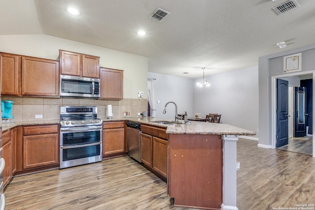 kitchen featuring visible vents, appliances with stainless steel finishes, a peninsula, and a sink