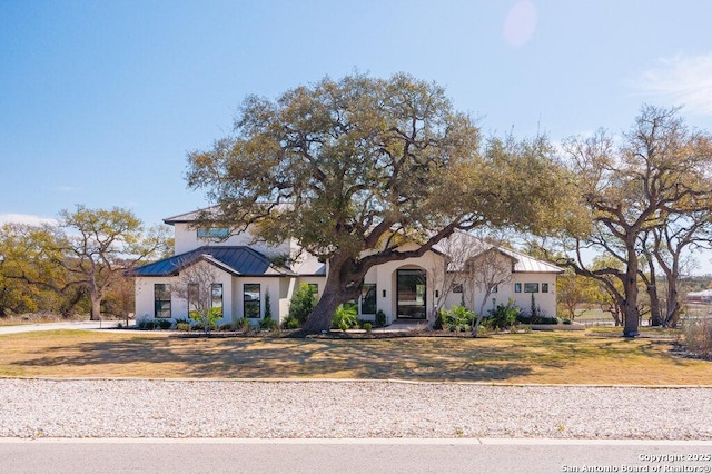 view of front of property featuring a standing seam roof, a front yard, and metal roof