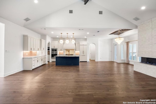 kitchen with a notable chandelier, stainless steel microwave, visible vents, and open floor plan