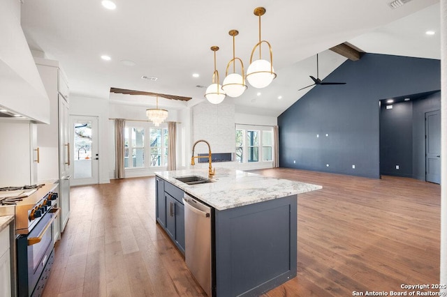 kitchen featuring beamed ceiling, custom range hood, a sink, wood finished floors, and appliances with stainless steel finishes