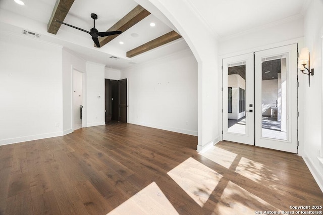 unfurnished room featuring beamed ceiling, a ceiling fan, wood finished floors, french doors, and arched walkways