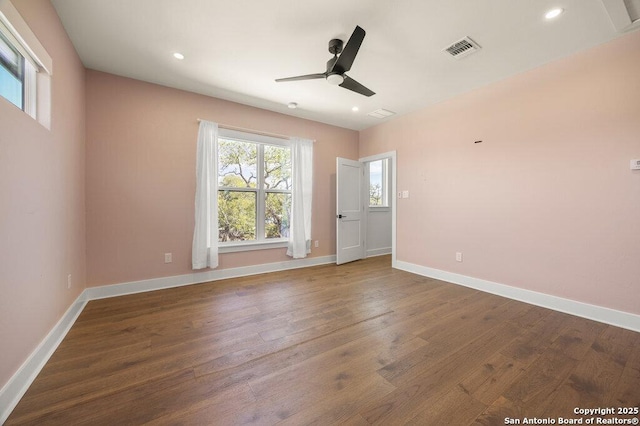 spare room with a ceiling fan, visible vents, baseboards, recessed lighting, and dark wood-style flooring