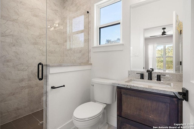 bathroom featuring toilet, a stall shower, vanity, and ceiling fan