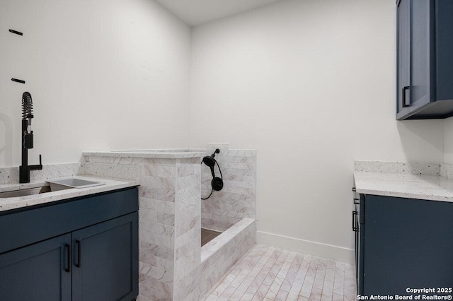 bathroom featuring baseboards, vanity, and a tile shower