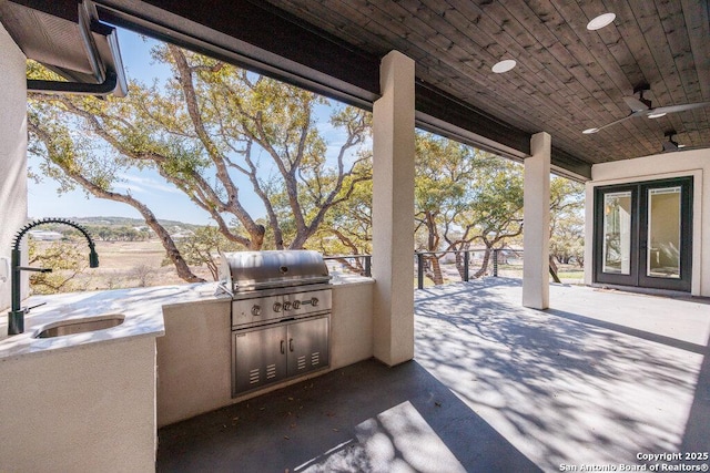 view of patio / terrace featuring ceiling fan, french doors, area for grilling, an outdoor kitchen, and a sink