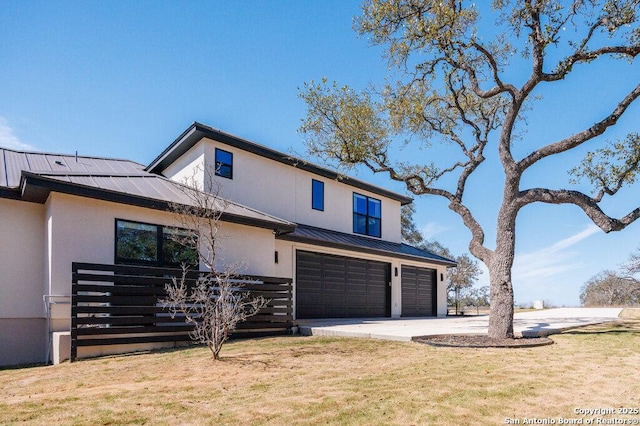 view of front of house featuring stucco siding, a garage, a standing seam roof, concrete driveway, and metal roof