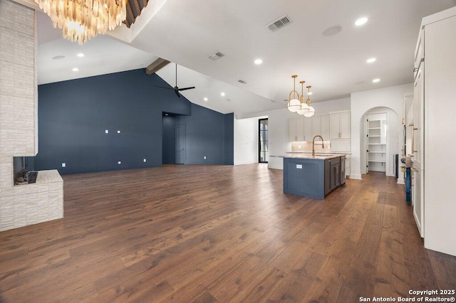 kitchen with visible vents, dark wood-type flooring, open floor plan, ceiling fan with notable chandelier, and white cabinetry