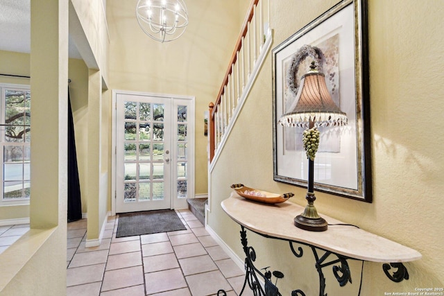 foyer with stairway, light tile patterned flooring, baseboards, and a wealth of natural light