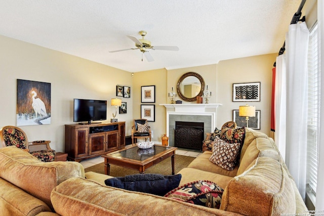 living area featuring a fireplace with flush hearth, a textured ceiling, and a ceiling fan