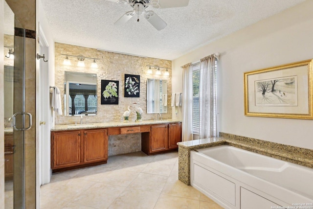 bathroom with a ceiling fan, double vanity, a stall shower, a sink, and a textured ceiling