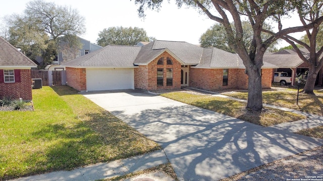 view of front of home featuring brick siding, a front lawn, concrete driveway, central AC, and an attached garage