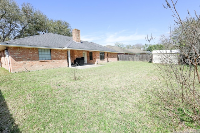 view of yard featuring a storage unit, a patio, an outbuilding, and fence