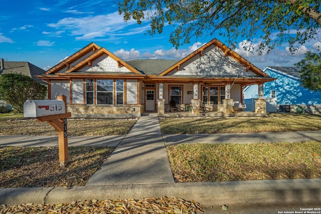 view of front of home with stone siding and a porch