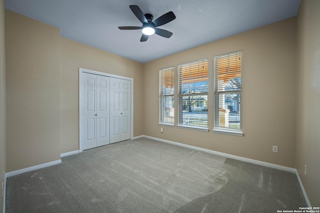 unfurnished bedroom featuring baseboards, carpet floors, and a closet