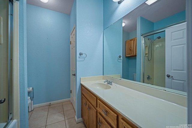 full bath with vanity, baseboards, tile patterned flooring, toilet, and a shower with door