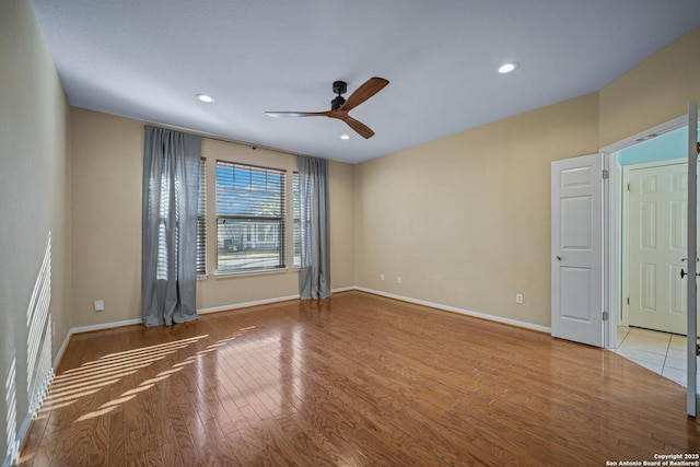 empty room with recessed lighting, wood finished floors, baseboards, and ceiling fan