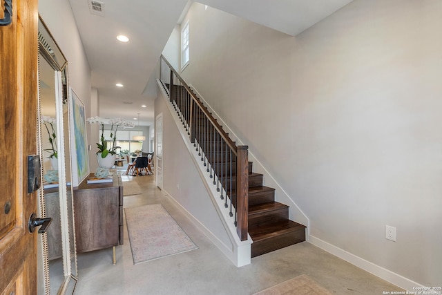 stairway with recessed lighting, visible vents, baseboards, and finished concrete floors