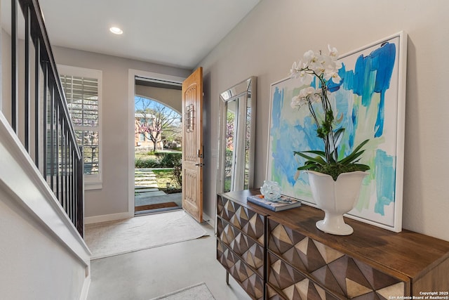 foyer with recessed lighting, finished concrete flooring, and baseboards