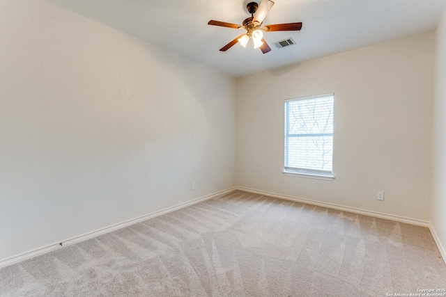 empty room featuring visible vents, light carpet, baseboards, and ceiling fan