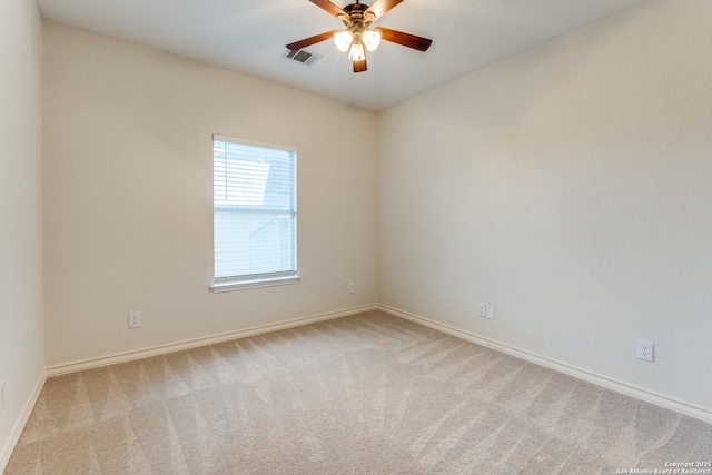 carpeted empty room with a ceiling fan, visible vents, and baseboards