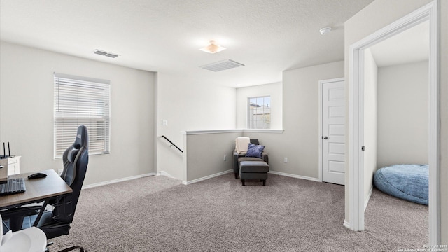 carpeted office featuring visible vents, baseboards, and a textured ceiling