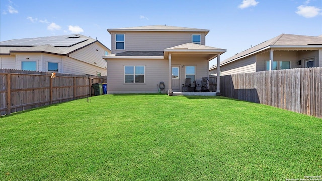 rear view of house with a lawn and a fenced backyard