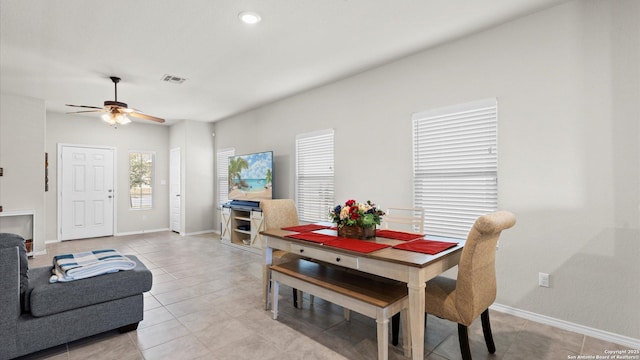 dining space with light tile patterned floors, visible vents, baseboards, and ceiling fan