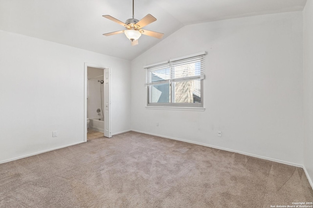 carpeted empty room featuring vaulted ceiling and ceiling fan