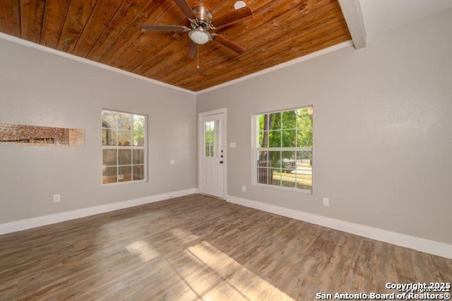 empty room featuring ornamental molding, wooden ceiling, baseboards, and wood finished floors