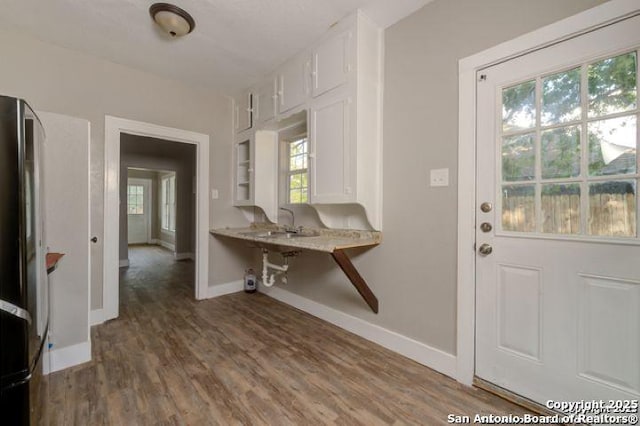 foyer featuring baseboards and wood finished floors