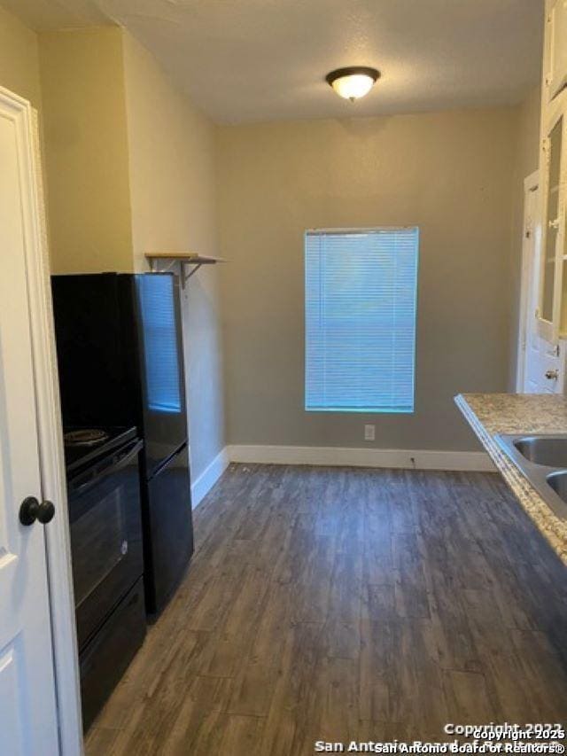 kitchen with black range with electric cooktop, baseboards, and wood finished floors