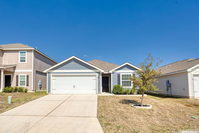 view of front facade featuring a front yard, an attached garage, and driveway