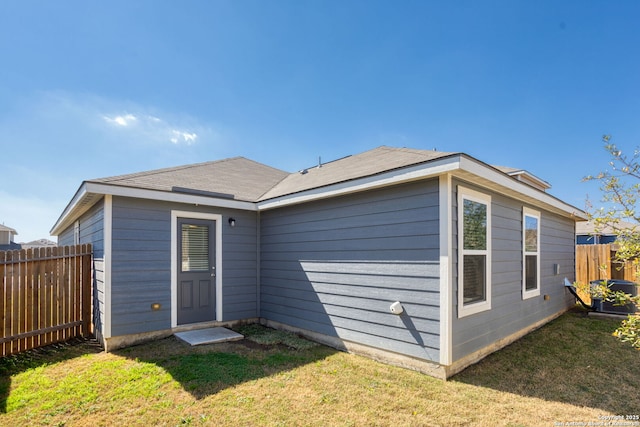 back of house featuring a yard and fence